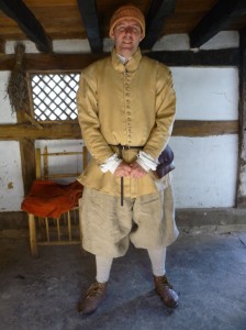 Aaron in Poplar Cottage wearing 'fustian' doublet, coarse canvas breeches & madder-dyed knitted woollen hat.